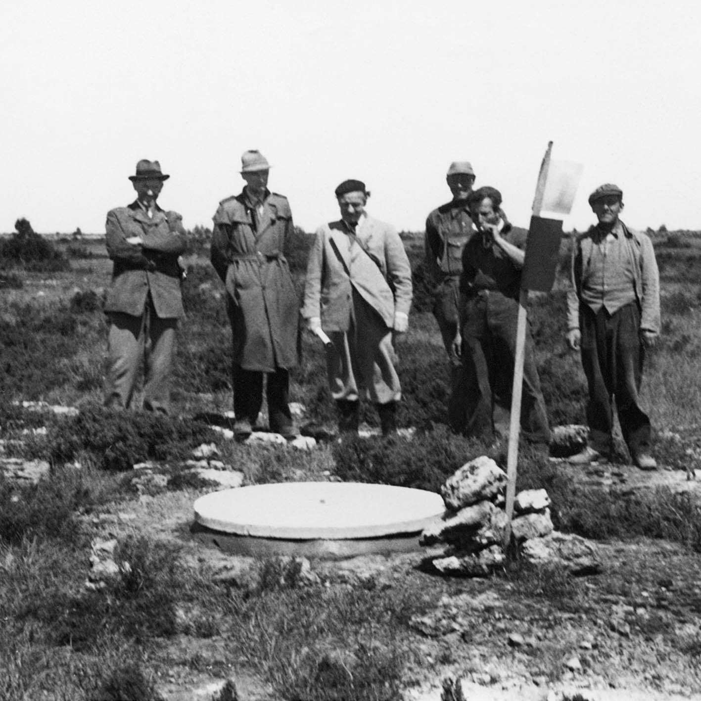 Inspektion 1955: Landsantikvarie Manne Hofrén (i basker) besöker fältet. Bertil Hallert till vänster, Gösta Jansson till höger (ägare till Stora Rörs Cementindustri som lägger ut locken). Bildägare: Gösta Jansson.